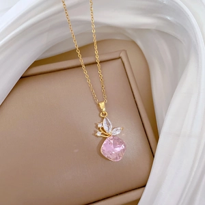 Macro shot of gold butterfly necklace with pink gemstone and rhinestones on silk