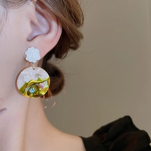 Close-up of vintage flower earrings with crystal butterfly and marble resin texture
