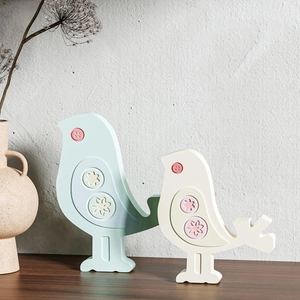 Detalle de figuras de pájaros en azul cielo y blanco crema con motivos florales