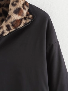 Detail shot of the faux fur leopard print collar and zipper on the black bomber jacket