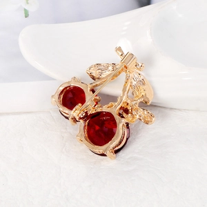 Chic cherry brooch with red crystals and gold metal finish shown from back view