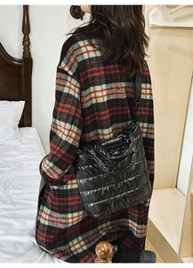 Close-up of black quilted down tote bag with a glossy finish and puffer padding texture