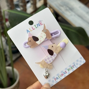 Detail of dog-shaped acrylic hair clips in lavender and cream with heart metal pendants