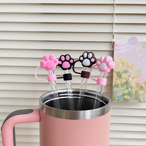 Close-up of cat paw silicone straw covers on glass straws in a pink tumbler cup