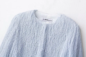 Detailed close-up of light blue tassel jacket neckline with BBWMWOMAN brand label