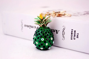 Macro shot of pineapple keychain with green crystals and gold metal leaf details