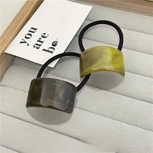 Detail of high-elasticity hair ties with polished marble-textured resin charms in two colors