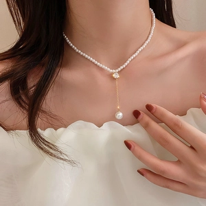 Gros plan d'un collier de perles vintage français avec pendentif coeur doré et strass
