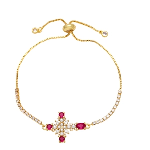 Adjustable gold cross bracelet with red gemstones and pearls on white background