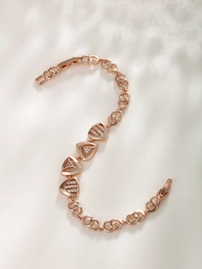 Detail of rose gold bracelet with triangle zircon charms in an S-shaped layout