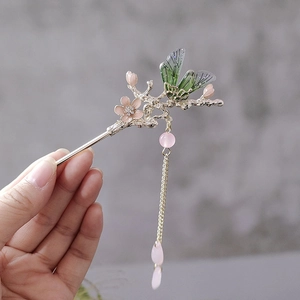 Detail of vintage pink flower hair pin with green butterfly and golden tassels