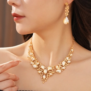 Close-up of champagne crystal necklace set with teardrop stones on elegant model neck