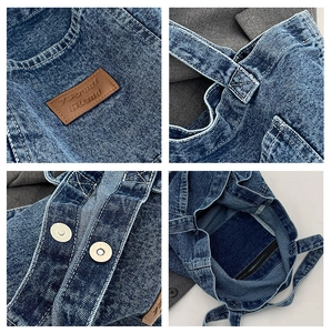 Detail of blue denim tote bag featuring vintage leather brand label and secure magnetic buckle
