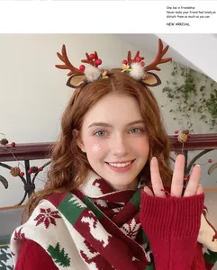 Detail of plush Christmas reindeer antlers headband with pine cones and red berries