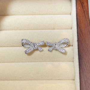 Macro detail of S925 sterling silver bow earrings with pavé zircons in a velvet box