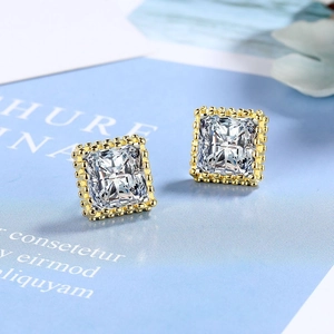 Square cut zircon stud earrings with golden beaded border on light blue background