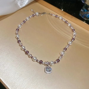 Detailed view of the zircon crystal square pendant and elegant pearl strand necklace