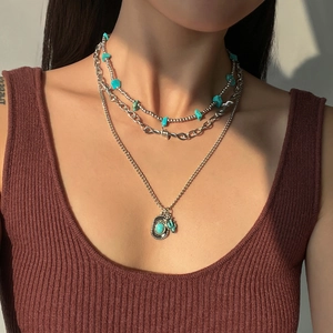 Detail view of layered turquoise necklace with bohemian silver pendant and beaded chains