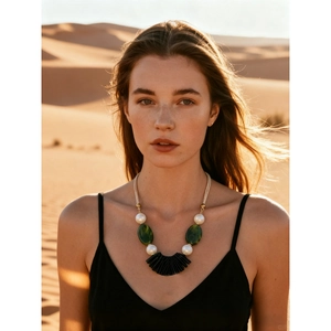 Boho layered acrylic oval pendant necklace with green beads on a desert background