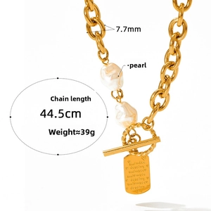 Macro detail of gold curb chain necklace with Baroque pearls and engraved Soulmate pendant