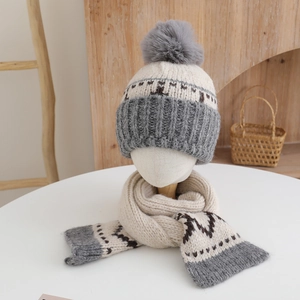Detailed view of beige and gray knitted kids beanie with pom-pom and matching scarf set