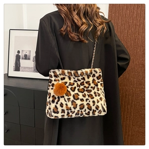 Detailed close-up of leopard print plush shoulder bag with golden chain strap and fur ball