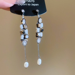 Macro view of zircon butterfly tassel earrings with teardrop beads and silver needles