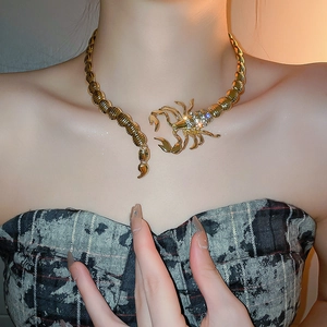 Detail of a gold scorpion choker with rhinestones worn on the neck for a bold look