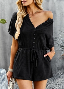 Detail showing waffle fabric texture, v-neck button opening and drawstring waist of black romper