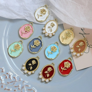 Macro view of rose enamel pendants with pearls in various colors for DIY jewelry
