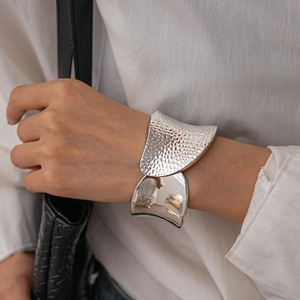 Macro view of silver chunky cuff bracelet featuring half-hammered and half-mirror finish