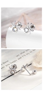 Detailed view of silver spider cartilage earring with iridescent opal stone and screw back