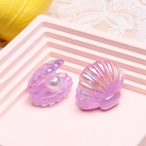 Macro detail of iridescent purple resin seashell charms with faux pearls for DIY crafts