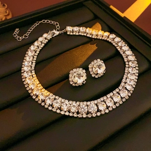 Macro detail of silver-tone square crystal necklace and earrings on professional display