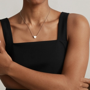 Minimalist 3D heart pendant necklace in polished finish worn on model collarbone