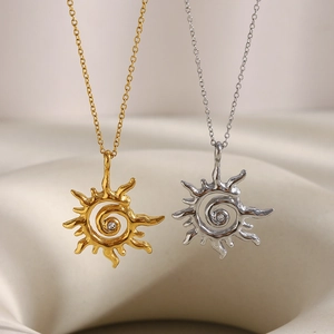 Collier avec pendentif soleil en acier inoxydable doré 18 carats et zircon sur tissu beige
