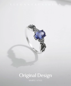 Detail of vintage oxidized silver ring with oval tanzanite blue stone and floral carving