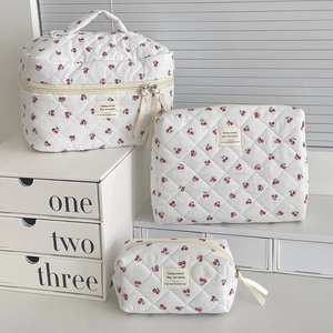 Detailed set of three quilted cherry print toiletry bags including a large vanity case