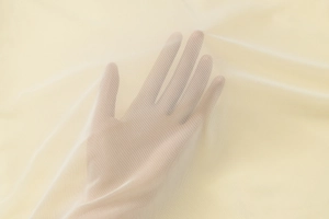 Makroaufnahme von atmungsaktivem beigem Netzstoff mit hoher Transparenz und Textur