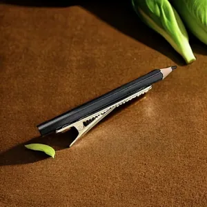 Barrette à cheveux créative en forme de crayon noir sur velours marron et décor