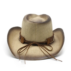 Macro detail of western straw cowboy hat with gradient edges and metal coin charms
