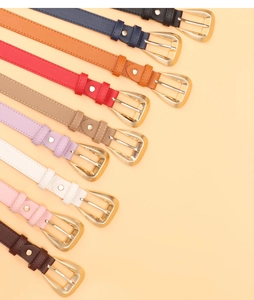 Close-up of colorful faux leather belts with gold D-shaped buckles in various shades