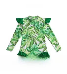 Close-up of girls' one-piece long sleeve swimsuit with tropical green palm leaf prints