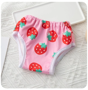 Close-up of pink dog diaper with strawberry print and elastic waistband on white background