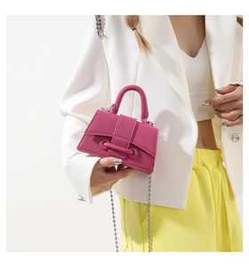 Detail of rose pink beaded chain mini handbag in litchi grain leather on fashion model