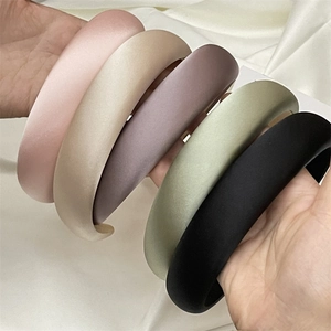 Detailed close-up of thick satin headbands in five elegant solid pastel colors