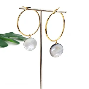 Detail view of 40mm gold hoop earrings with iridescent natural black shell pendants