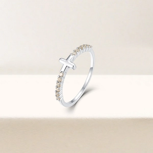 Detail of S925 silver cross ring with champagne zircon pavé on beige stone steps