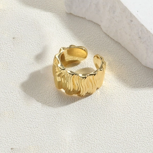 Detailed macro view of the irregular gold wave texture on this adjustable metal ring