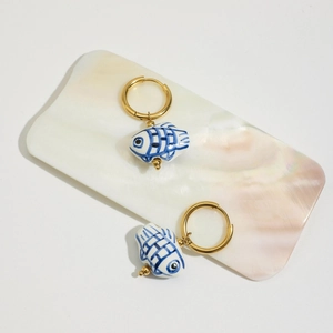 Dettaglio di orecchini placcati oro 18K con pendenti a pesce in ceramica e motivi blu